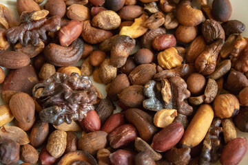 Plate with assorted nuts on a white background.