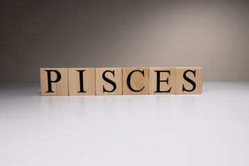 Pisces word on wooden cubes on white background.