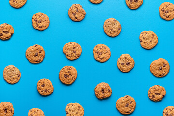Fototapeta na wymiar Chocolate chip cookies background. Cookies pattern on blue color