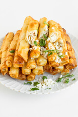 Traditional Turkish "Sigara Borek",cruncy,cheesy and savory great appetizers finger food in the white porcelain plate.Vertical image.