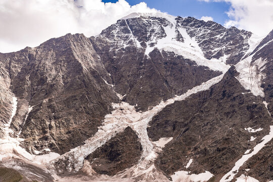 High snowy Caucasian mountains with a glacier with the form of a figure of seven number. Peaks of the mountains Donguz Orun and Nakra Tau. Elbrus region, Cheget.