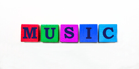 The word music written on wooden multi-colored cubes on a light background