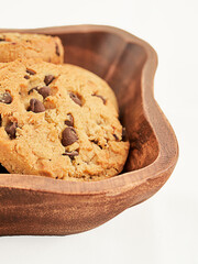 Cookies on wooden bowl on white background.