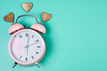 Detail close up of the old pink vintage alarm clock on colour background with free copy space.