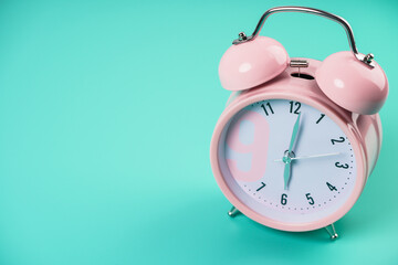 Detail close up of the old pink vintage alarm clock on colour background with free copy space.