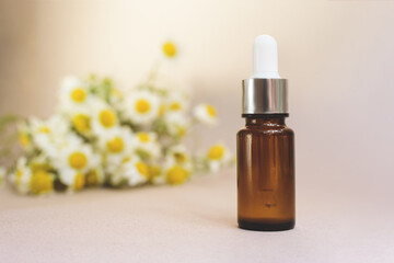 Fototapeta premium A glass dropper bottle on the beige background.