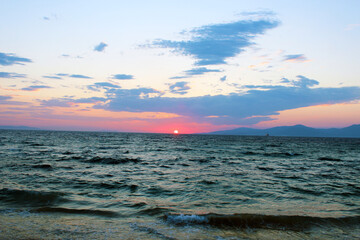 Beautiful sunset view in Oia, Santorini, Greece. The sun is setting behind the sea. Romantic and wonderful view.