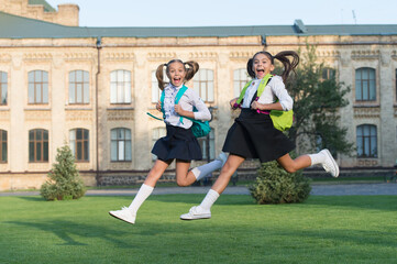 Happy last day of school. School children in high jump. School holidays. Energetic children in...
