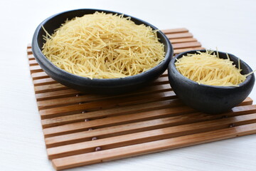 Short pasta spaghetti angel hair displayed in containers on white background
