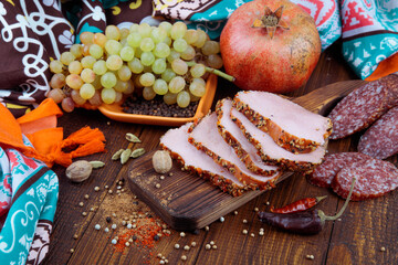 
red meat beef with fruit grape pomegranate on a cutting board with spices