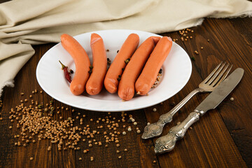 sausages with herbs on a white plate wooden background
