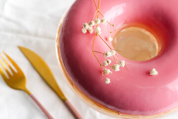 Close up view of homemade fruits pink glazed souffle served fork and knife on a textile white background.