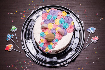 Cake with a multi-colored cream decoration that looks like a funny face. Children's birthday, concept