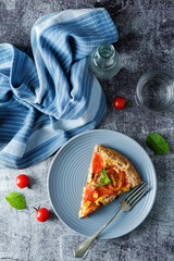 Onion tomato cream cheese wholegrain galette in a plate