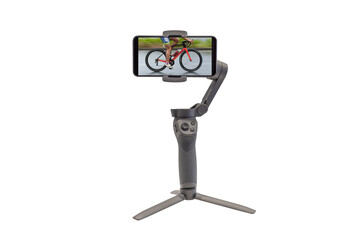 smartphone on a stabilizer with the image of a cyclist on the screen isolated on a white background
