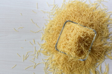 Short pasta spaghetti angel hair displayed in containers on white background