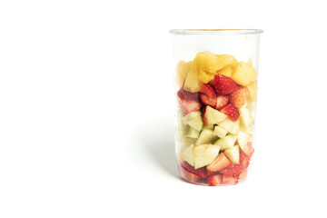 Chopped fruit in the plastic dish on white background. Nectarine, strawberry, apple.