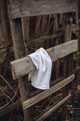 Fototapeta na wymiar White towel hanging on old wooden ladder