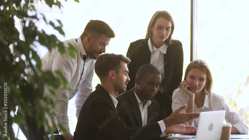 Wall mural Multi racial well-dressed employees working together on project using application look at pc screen, team leader european businessman telling about apps corporate program, teamwork leadership concept