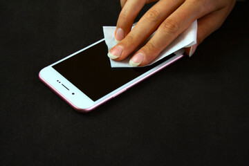 Cleaning the smartphone surface using a wet wipe to clean touch screens