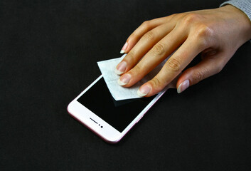 Czyszczenie powierzchni smartfona przy pomocy nawilżanej chusteczki do czyszczenia ekranów dotykowych