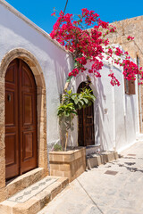 Fototapeta na wymiar Traditional greek house with spring flowers on Rhodes island. Lindos village, Dodecanese, Greece.