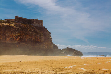 Lighthouse and Fort of Sao Miguel above North beach at Nazare, Portugal