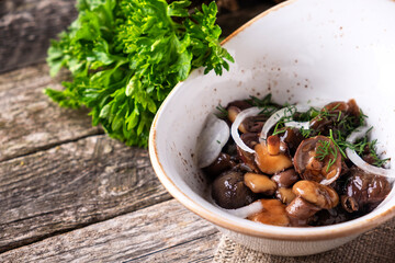 Pickled  mushrooms with onion in a bowl. Copy space