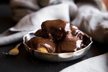 Delicious eclairs with cream and chocolate frosting on a plate