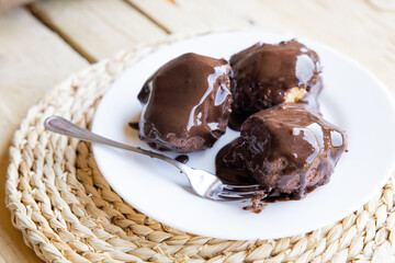 Delicious eclairs with cream and chocolate frosting on a plate