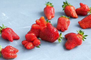 Fresh juicy berries. Organic strawberries of unusual shape. Trendy ugly fruits