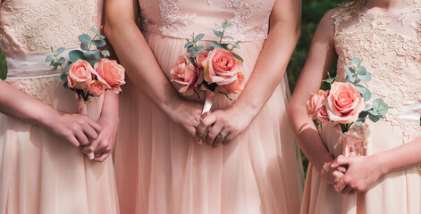 Three bridesmaids in peach with bouquets - obrazy, fototapety, plakaty