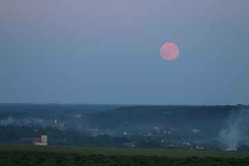 Rising red moon over the city of Sülysáp. Panoramic view from.