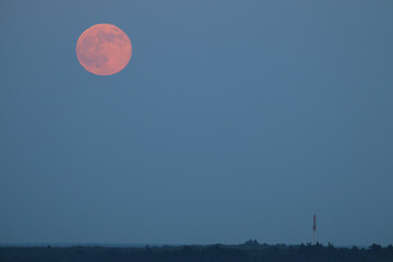 Rising red moon over the city of Sülysáp. Panoramic view from.