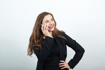 Smile having talking conversation with mobile phone. Young attractive woman brunette in a black t-shirt and sweater on white background