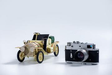Tourism and travel concept - Vintage camera and tin vintage car model on a white background 