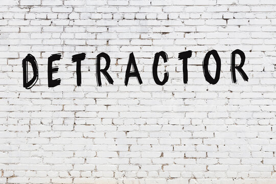 Word detractor painted on white brick wall