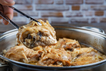 Chicken thighs are fried in a pan and served with spitz on a plate, close-up, shallow depth of field, selective focus. Homemade food concept.