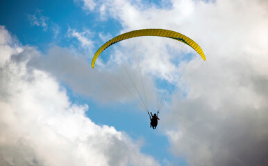 paraglider on a background of clouds and blue sky