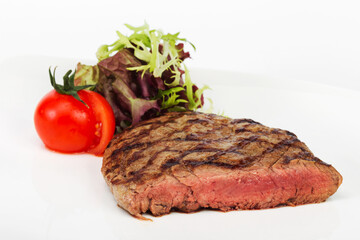 Steak with blood of beef with tomatoes, herbs and lettuce, selective focus. For design of menus, cookbooks, advertising products for the restaurant business
