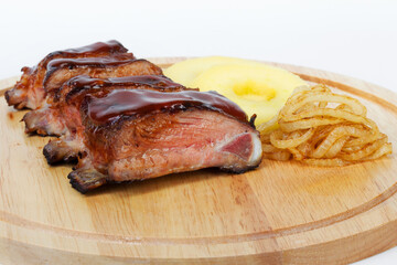 Pork ribs Chelogach with fried onions and slices of fresh apples. For design of menus, cookbooks, advertising products for the restaurant business