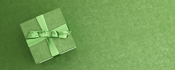 Mock-up poster, emerald green luxury gift box with shiny bow on shamrock green background, 3D...