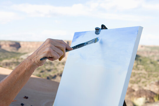 senior woman artist painting mountain landscape, White Rock, New Mexico
