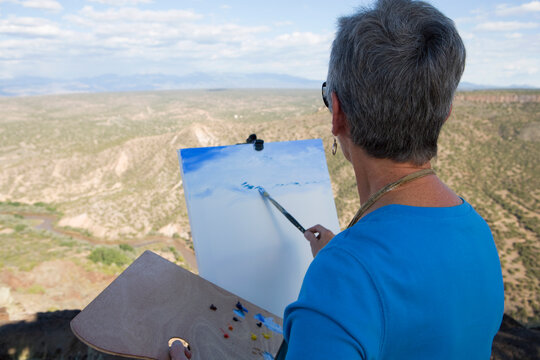 senior woman artist painting mountain landscape, White Rock, New Mexico