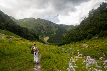 Fototapeta na wymiar Woman Hiker trekking in mountains with child in backpack . 