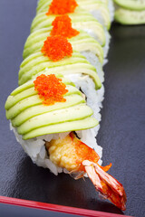 Maki Sushi with Salmon, red caviar on black tray. Selective focus. As backdrop for menus, cookbooks, advertisements and other culinary projects