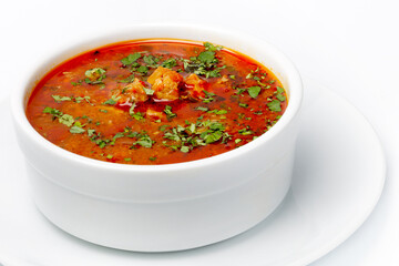 Borsch soup with meat, tomatoes and herbs in white cup closeup as background for restaurant menu, cafe, cookbook, advertising business.