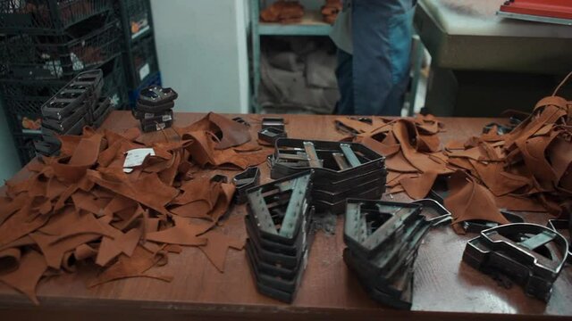 people working with press machinery for cutting shoe leather