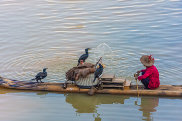 YANGSHUO, CHINA, 6 DECEMBER 2019: Cormorant fisherman on the Li River in Yangshuo
