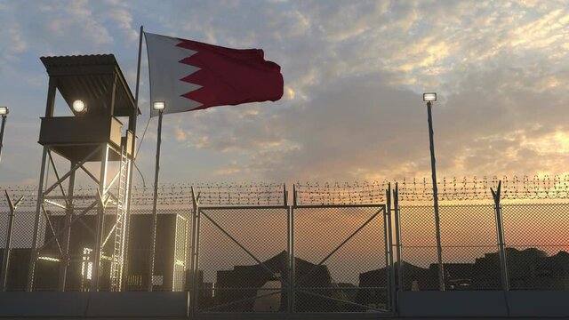 Waving flag of Bahrain above military base in the evening